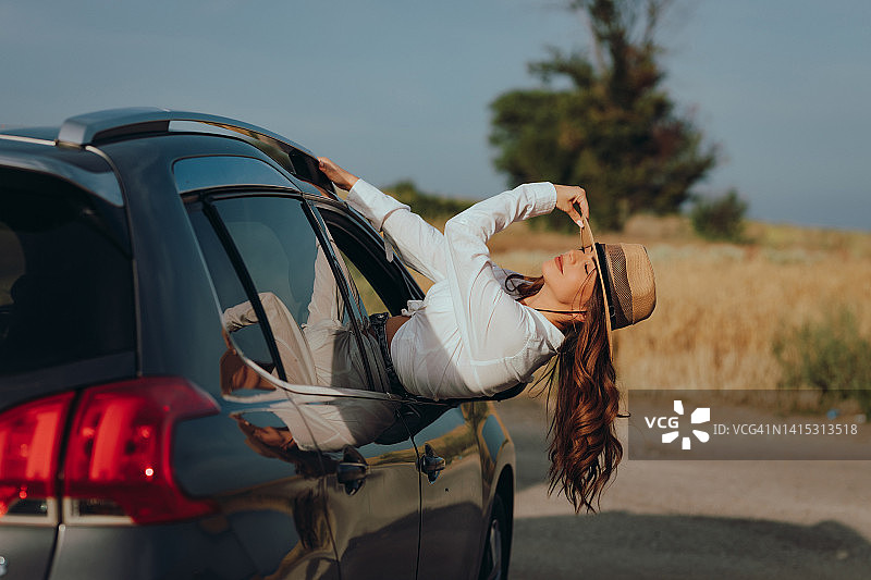 女子在阳光明媚的日子里享受自驾游图片素材