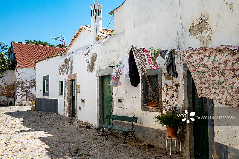 阳光下晾晒衣物的传统房屋图片素材