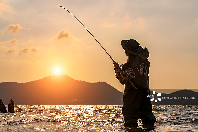 垂钓者在夏季日出时捕鱼图片素材