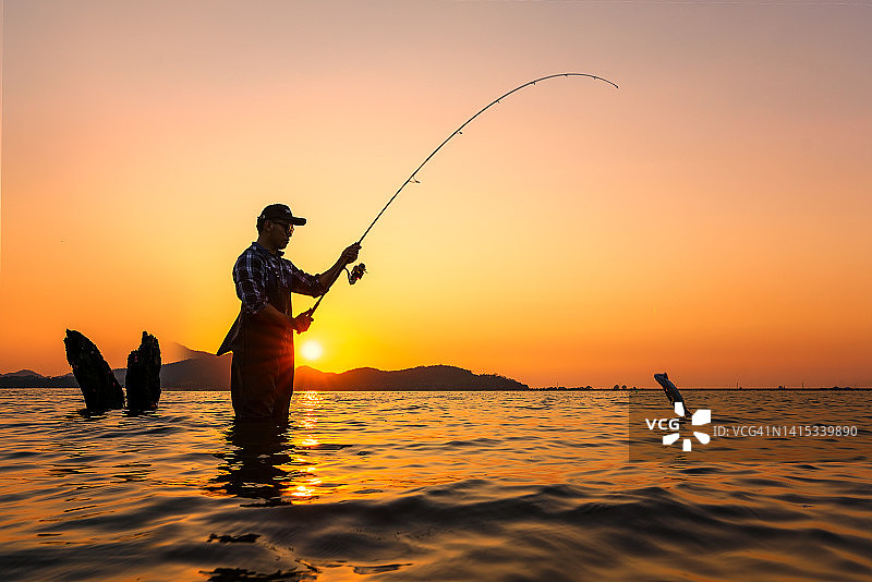 垂钓者在夏季日出时捕鱼图片素材