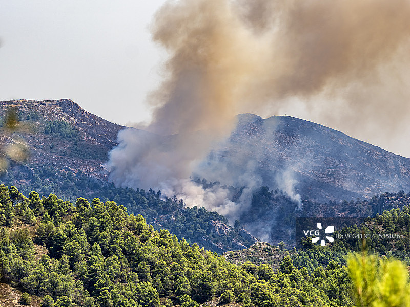 地中海森林山地景观与森林火灾的烟雾图片素材