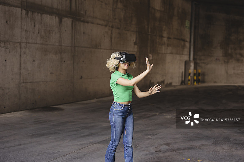 年轻女子在停车场佩戴VR模拟器图片素材