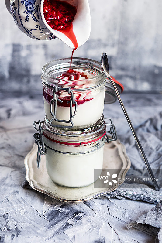 自制冻酸奶上倾倒树莓酱图片素材