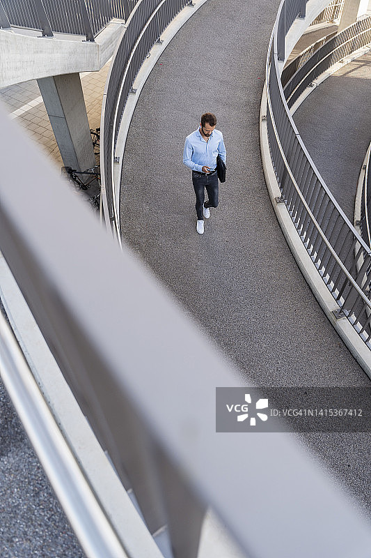 在人行天桥上使用智能手机的商人图片素材