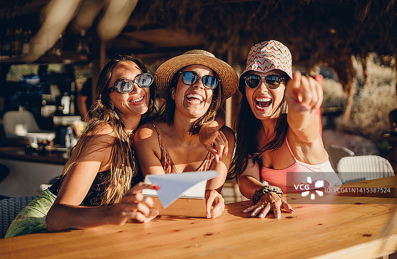 在海滩酒吧里举杯欢庆的女孩们图片素材