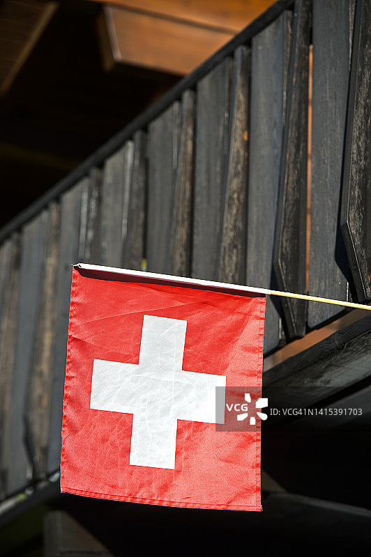 瑞士国旗在瑞士瓦莱州的木屋上飘扬图片素材