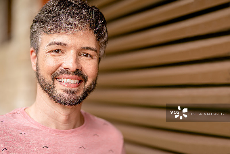 微笑的男人站在家里的露台上图片素材