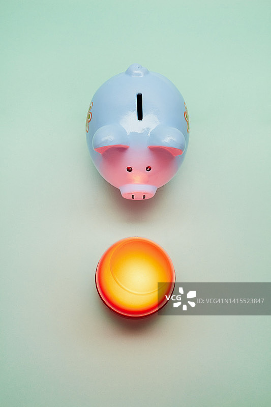 绿色背景上的存钱罐和照明灯，节省能源成本图片素材