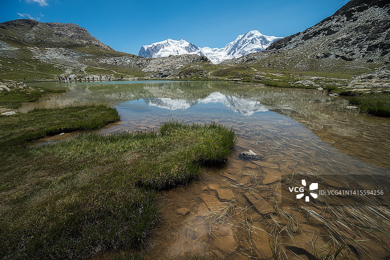 在晴朗天气里，一群游客在里弗尔湖边休息，他们正在进行长途跋涉图片素材