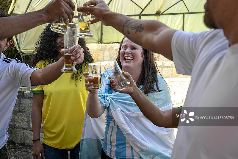 两支足球队的球迷，阿根廷和巴西在比赛开始前一起喝啤酒聊天图片素材