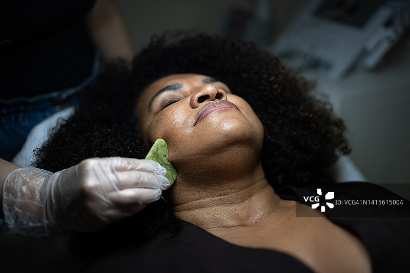 中年妇女在美容水疗馆接受刮痧按摩图片素材