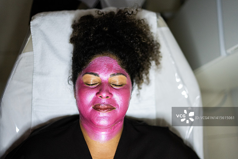 女人在美容水疗中心敷面膜放松图片素材