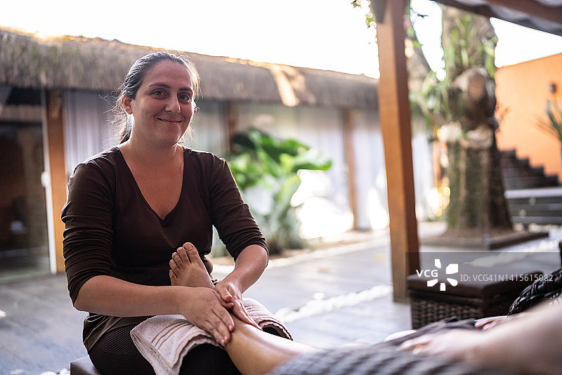 按摩师为顾客做腿部按摩的肖像图片素材