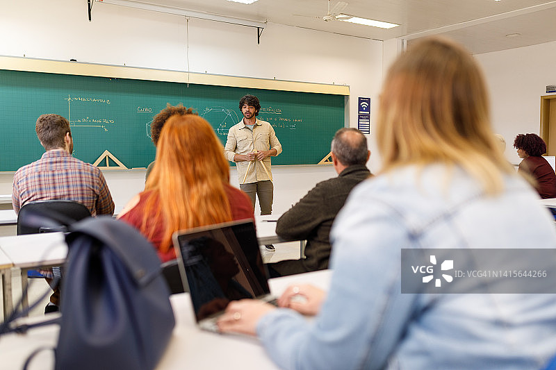 课堂上学生用笔记本电脑记录教授的讲解图片素材