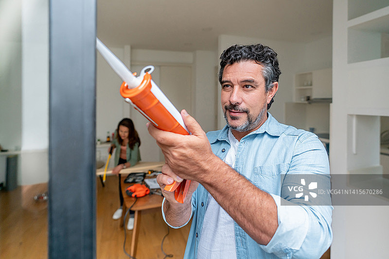 男人在家粉刷阳台门图片素材