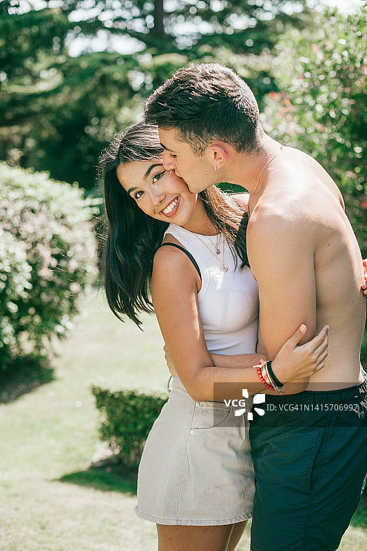 在阳光明媚的日子里亲吻的年轻拉丁裔异性恋情侣图片素材