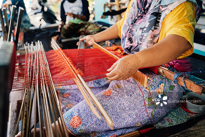 在印度尼西亚传统织布机上工作的亚洲女性图片素材