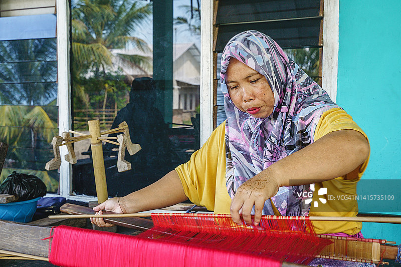 年轻穆斯林妇女在印度尼西亚传统织布厂工作图片素材