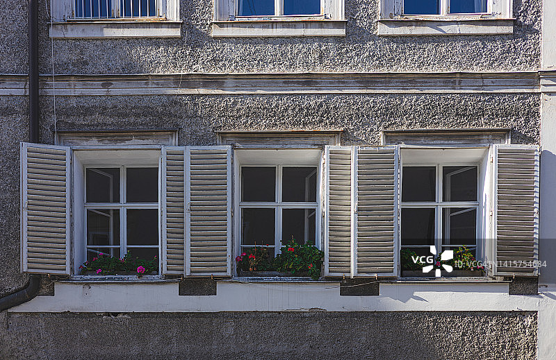萨尔茨堡老建筑上的百叶窗与盆栽图片素材