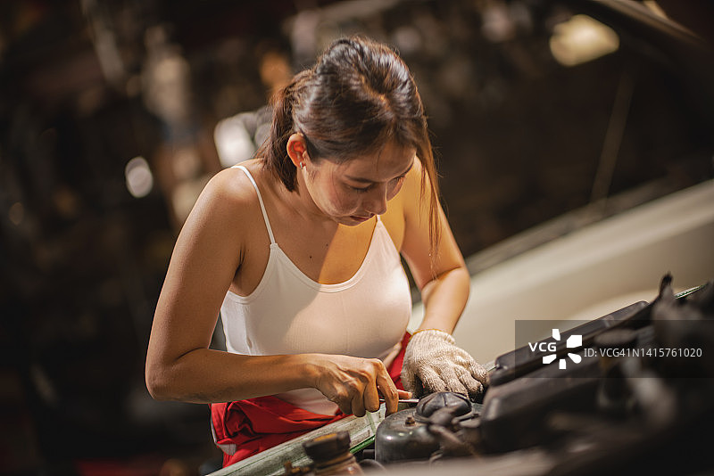 在汽车修理店修理汽车的女人肖像图片素材