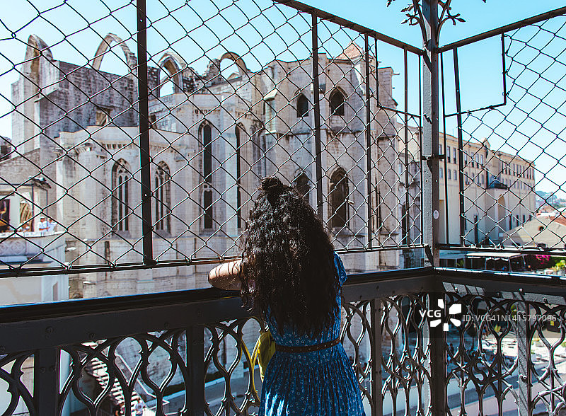 女人透过栅栏眺望卡尔莫修道院图片素材