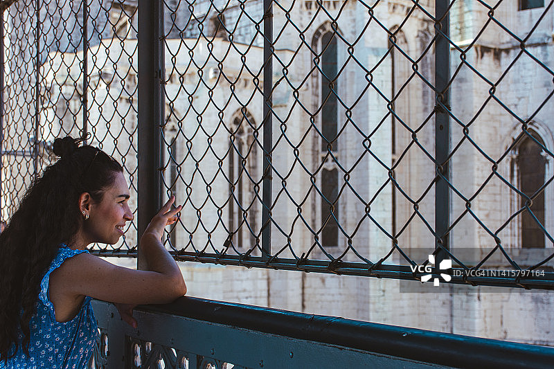 女人透过栅栏眺望卡尔莫修道院图片素材