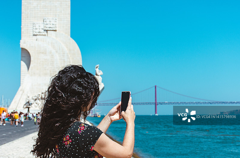 游客在特茹河边使用手机的背影图片素材