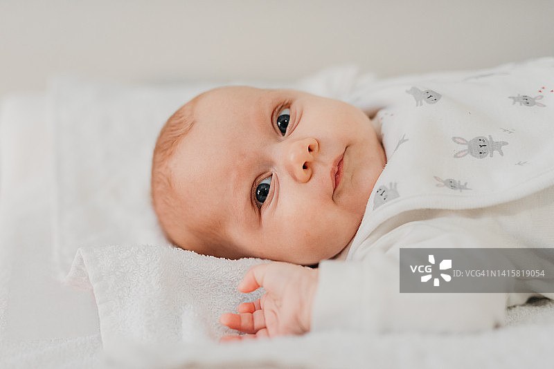 躺在毛巾上的大眼睛宝宝肖像图片素材