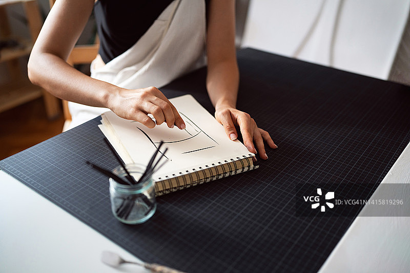 在工作室用木炭绘画的匿名女人图片素材