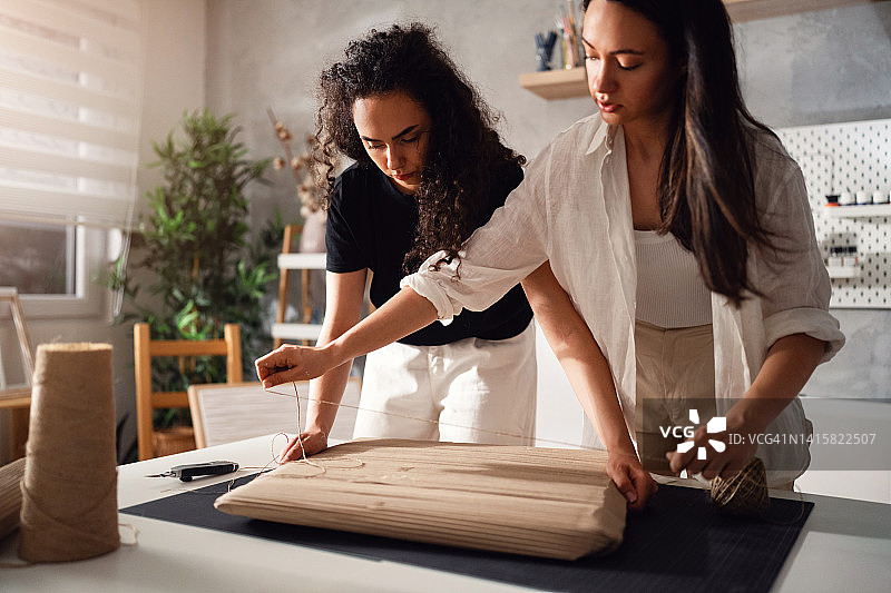 姐妹艺术家和线上卖家正在打包画作准备发货图片素材