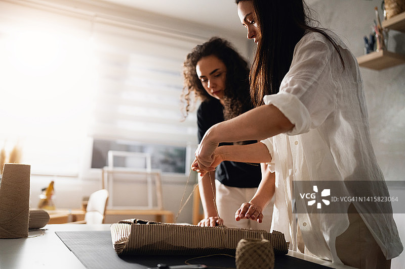 姐妹艺术家和线上卖家正在打包画作准备发货图片素材