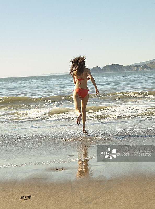 比基尼女人奔向海浪图片素材