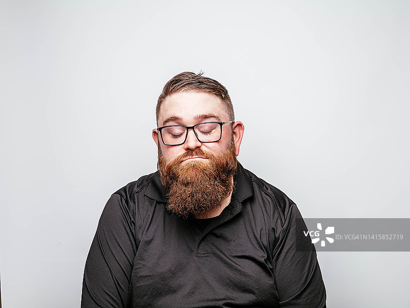 面容严肃的络腮胡男人，穿着黑色衬衫图片素材