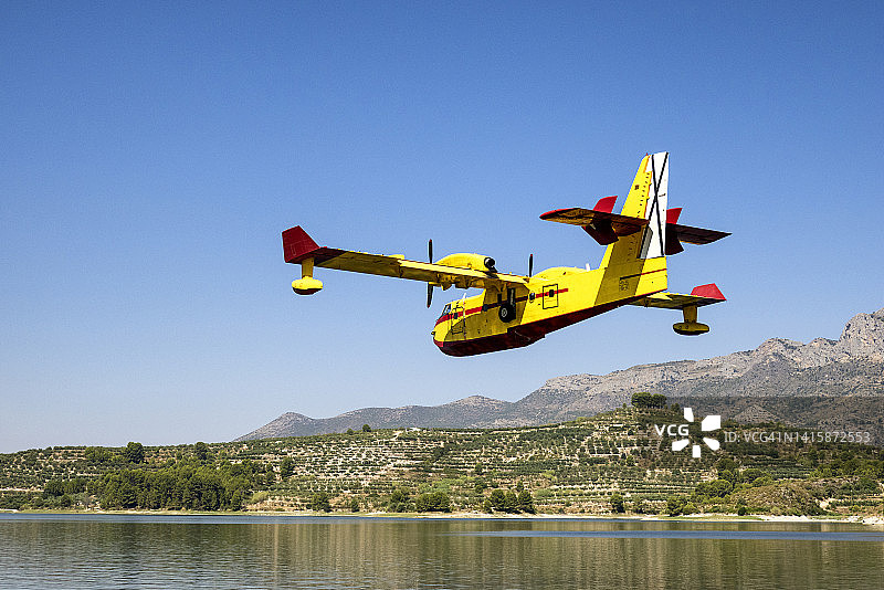 水陆两用飞机在水库水面降落，汲水以扑灭森林火灾。图片素材