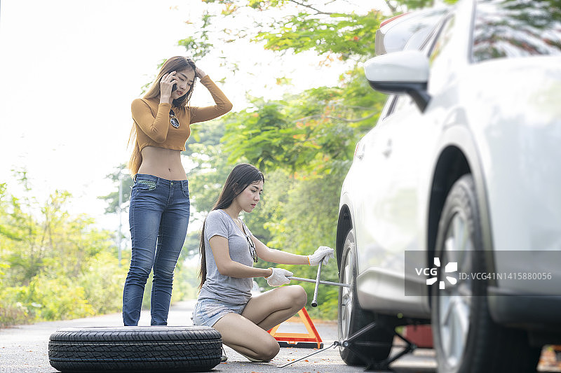 两个年轻女人旅行时车坏了图片素材