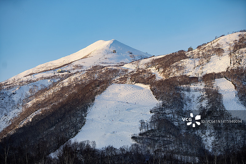 被白雪覆盖的富士山羊蹄山和新雪谷村庄附近的冬季森林美景，日本北海道，2019年图片素材