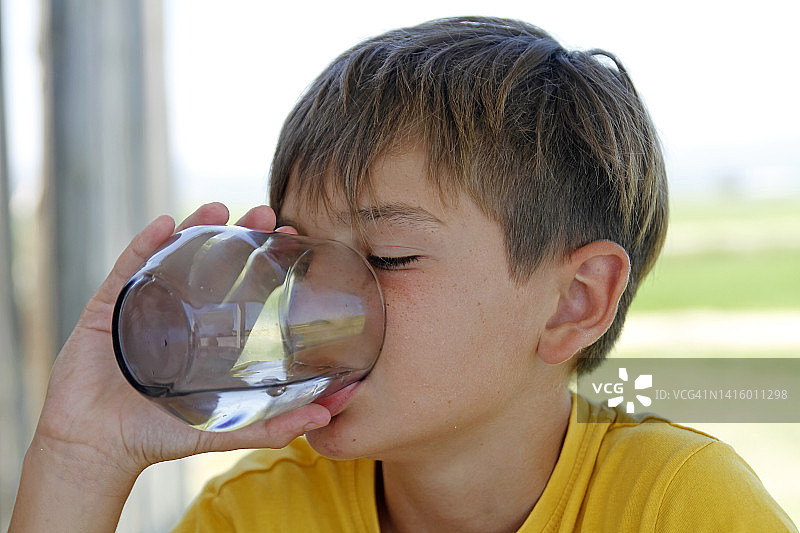 男孩在喝一杯水图片素材