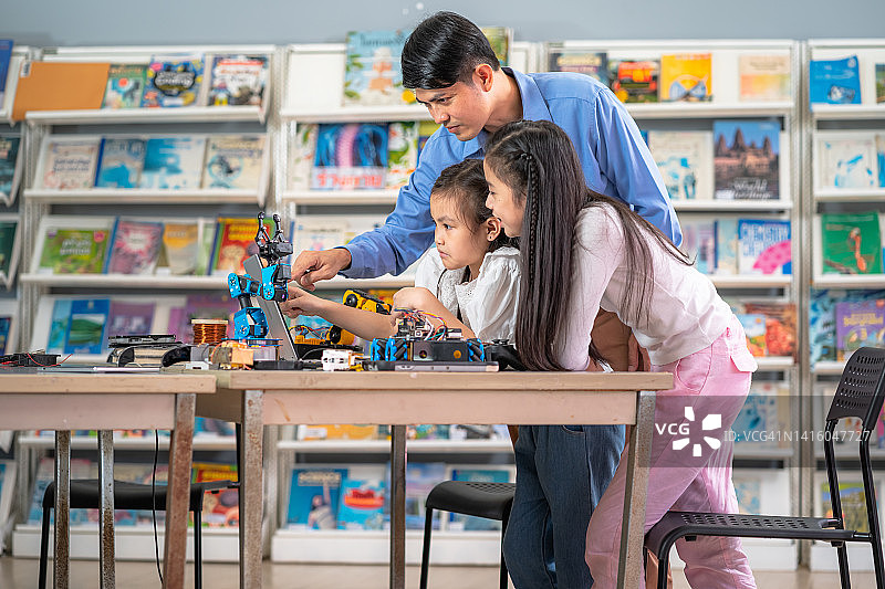 老师教孩子们组装机器人，教室里的机器人，教育理念，创新，技术，智力和天赋图片素材