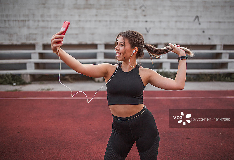 微笑的女运动员在户外训练后自拍图片素材