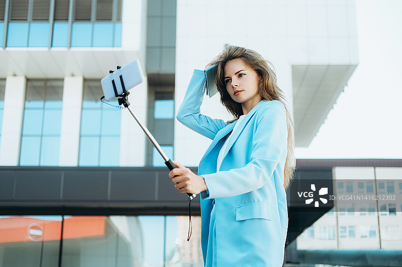 年轻女人在户外用手机自拍图片素材