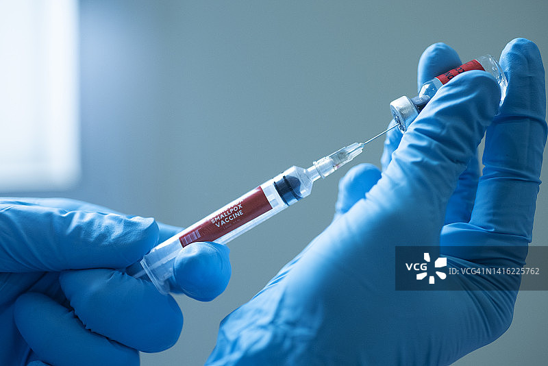 特写：医生手持注射器，猴痘疫苗与采血管图片素材