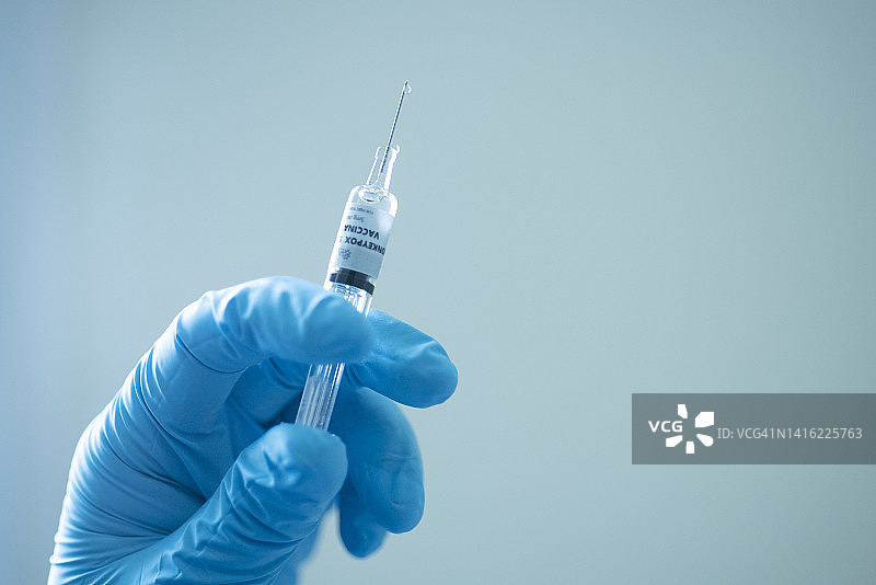 特写：医生手持注射器，猴痘疫苗与采血管图片素材