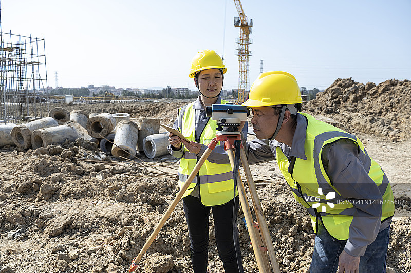 两名工程师正在使用测量仪器在现场工作图片素材
