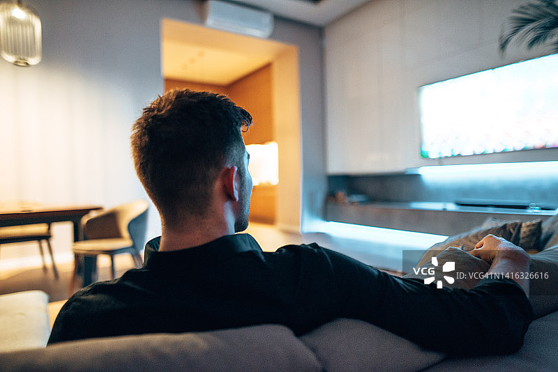 在沙发上看电视的男人图片素材