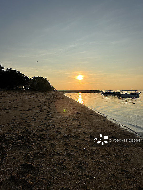 巴厘岛沙努尔海滩日出时的船只图片素材