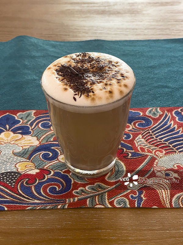 中式彩色布艺上的拿铁咖啡图片素材