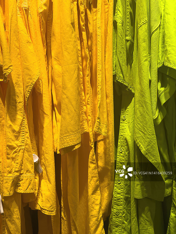绿橙色衣服挂在衣架上图片素材