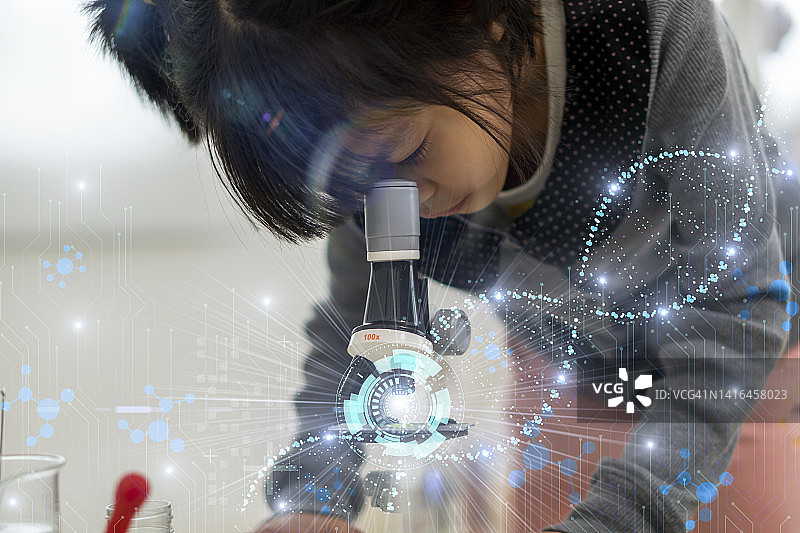 亚洲女童在学校化学实验室里用显微镜观察图片素材