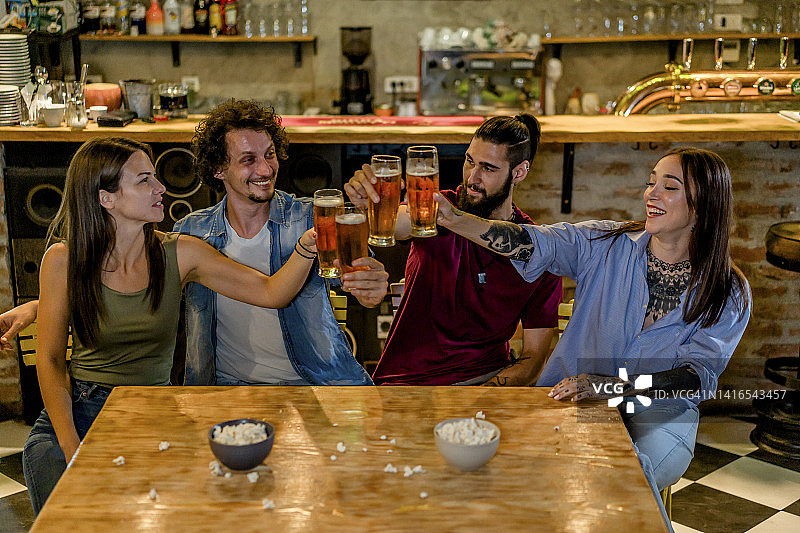 年轻朋友在酒吧里敬酒图片素材