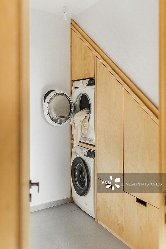 带内置洗烘一体机的现代衣帽间，木制衣柜，简约斯堪的纳维亚风格图片素材